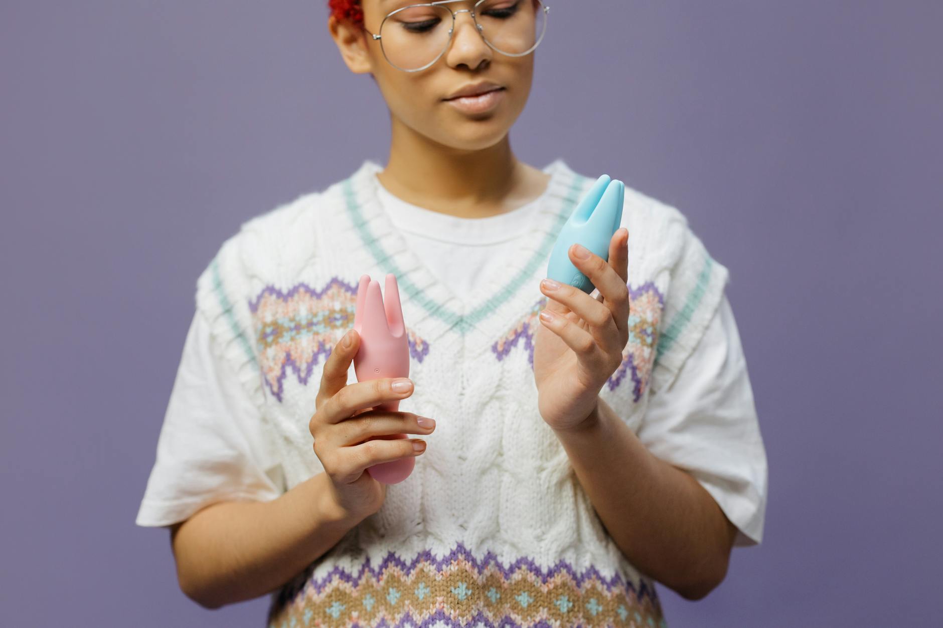 Woman holding vibrators in contemplative moment of self-discovery
