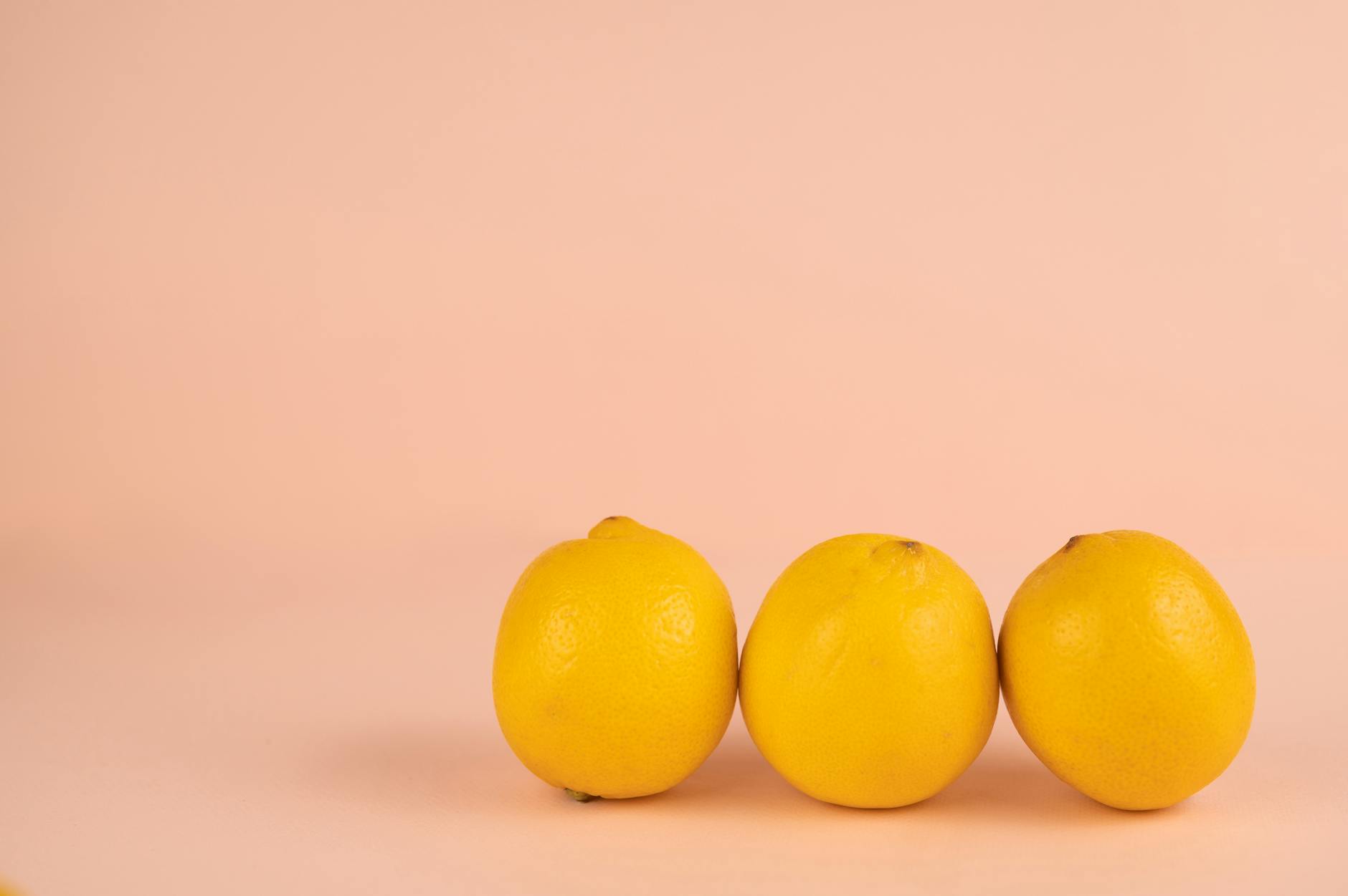Bright ripe lemons arranged on a pastel background, symbolizing the gentle intensity of lemon clitoral vibrators